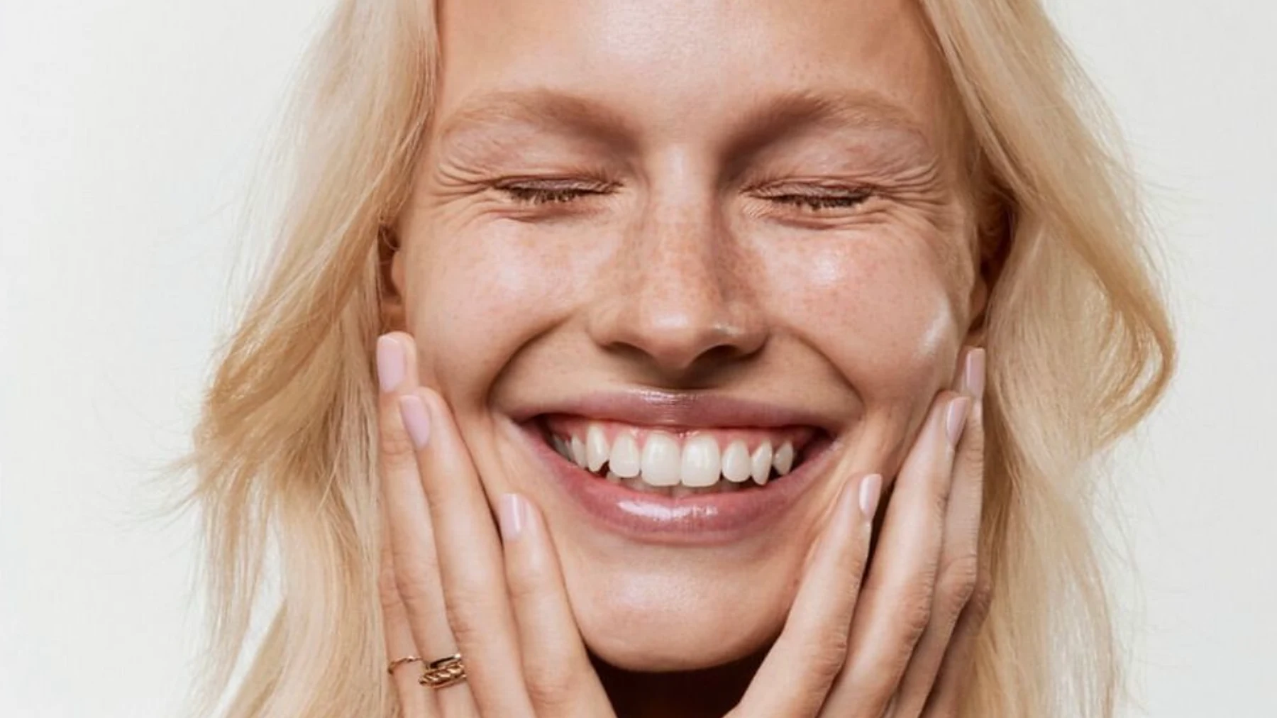 Femme souriante, les mains sur le visage